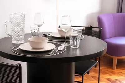 a black table with two plates and glasses on it at Blue Moon Studio in Porto