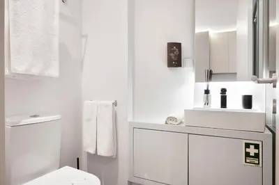 a white bathroom with a toilet and a sink at Blue Moon Studio in Porto