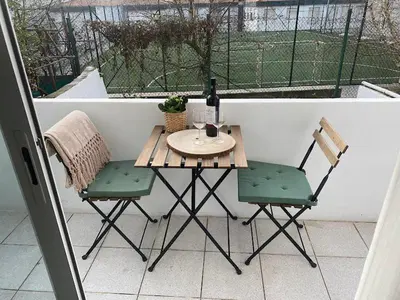 a small table and two chairs on a balcony at Lapa City Loft in Porto