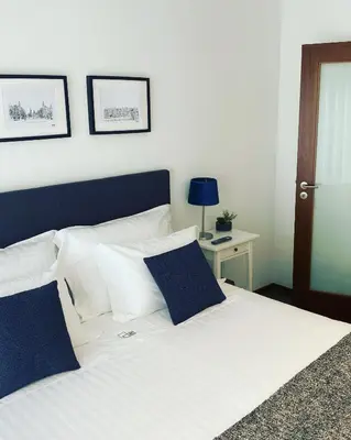 a bedroom with a white bed with blue pillows at Lapa City Loft in Porto