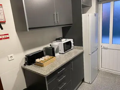 a kitchen with a counter with a microwave and a refrigerator at Lapa City Loft in Porto