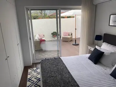 a bedroom with a bed and a balcony with a patio at Lapa City Loft in Porto
