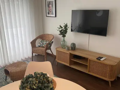a living room with a flat screen tv on a wall at Lapa City Loft in Porto