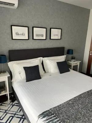 a bedroom with a large white bed with three pictures on the wall at Lapa City Loft in Porto