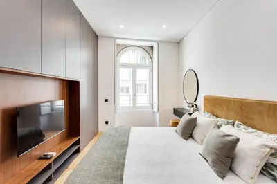 a bedroom with a bed and a television at Conceição Premium Downtown Apartment by DA'HOME in Porto