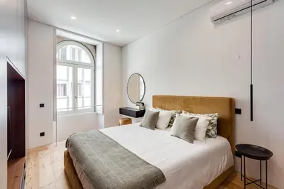 a bedroom with a large bed and a mirror at Conceição Premium Downtown Apartment by DA'HOME in Porto