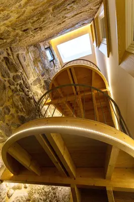 a wooden spiral staircase in a stone building at Riverside 2 Bedroom Apartment by DA'HOME in Porto