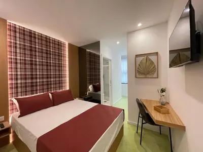 a bedroom with a bed and a table and a desk at MyStay Porto São Bento in Porto
