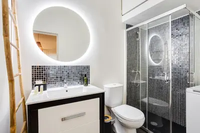 a bathroom with a toilet and a sink and a mirror at Virtudes Premium Apartment by DA'HOME in Porto