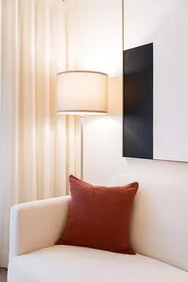 a white couch with a red pillow and a lamp at Virtudes Premium Apartment by DA'HOME in Porto