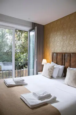 a bedroom with a large bed with towels on it at Almada Downtown Apartment by DA'HOME in Porto