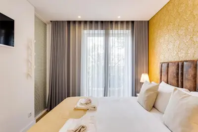 a bedroom with a large bed with towels on it at Almada Downtown Apartment by DA'HOME in Porto