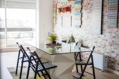 a dining room with a glass table and a brick wall at HEART OF THE CITY 3 ! in Vila Nova de Gaia