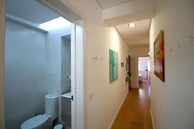 a white bathroom with a toilet and a hallway at HEART OF THE CITY 5 ! in Porto