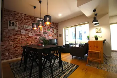 a dining room with a black table and a brick wall at HEART OF THE CITY 5 ! in Porto
