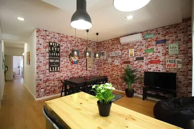 a living room with a table and a brick wall at HEART OF THE CITY 5 ! in Porto