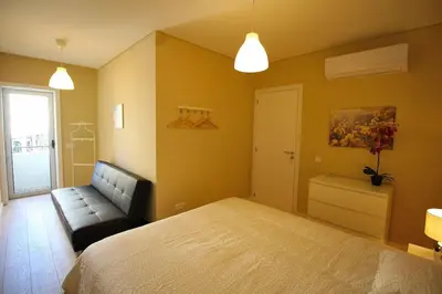 a bedroom with a bed and a couch at HEART OF THE CITY 7 ! in Vila Nova de Gaia