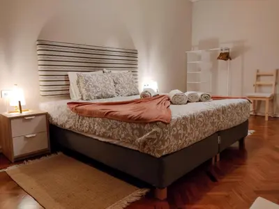 a bedroom with a large bed with a wooden headboard at Salty Swell in Porto