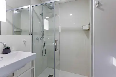 a shower with a glass door next to a sink at Downtown Studio w/ Gorgeous Views by LovelyStay in Porto