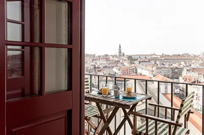 a table on a balcony with a view of a city at Downtown Studio w/ Gorgeous Views by LovelyStay in Porto