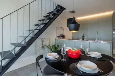 a living room with a table and chairs and a staircase at Panoramic Historic Views Private Balconies - Apt E in Porto