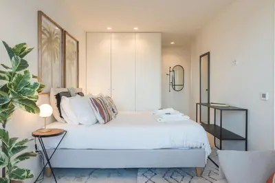 a bedroom with a white bed and a plant at Liiiving in Porto - Luxury Gallery Apartment II in Porto