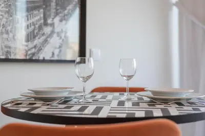 a table with two wine glasses and plates on it at Liiiving in Porto - Luxury Gallery Apartment II in Porto