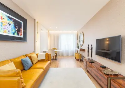 a living room with a yellow couch and a television at OPorto Design Flat in Porto