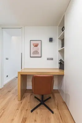 an office with a wooden desk and a brown chair at OPorto Design Flat in Porto