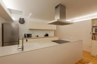 a white kitchen with a sink and a refrigerator at ORM Torrinha Apartment in Porto