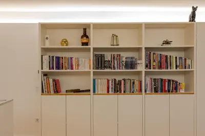 a book shelf filled with books and a bottle of wine at ORM Torrinha Apartment in Porto