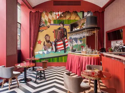 a restaurant with a bar with a painting on the wall at The Editory Boulevard Aliados Hotel - Preferred Hotels in Porto