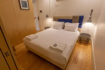 a bedroom with a white bed with two towels on it at ORM - Almada Balcony Apartment in Porto