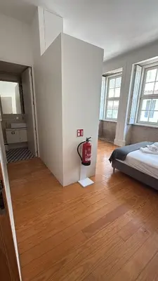 a bedroom with a bed and wooden floors and windows at Great&Cosy São Bento in Porto