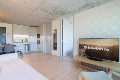 a living room with a large flat screen tv on a wall at Host Wise - Luxurious Impressive Apartment - Balcony and Pool in Vila Nova de Gaia