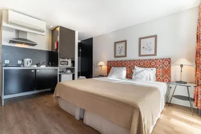 a hotel room with a large bed and a kitchen at Casa Dos Caldeireiros in Porto