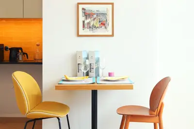 a table with two chairs sitting next to a kitchen at Villa Invicta II in Porto