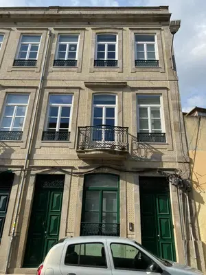 a car parked in front of a building with green doors at Villa Invicta II in Porto