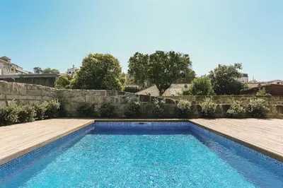a swimming pool in a yard with a retaining wall at ORM Carregal Apartment in Porto