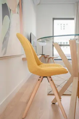 a yellow chair sitting next to a glass table at Liiiving in Porto - City Design Apartments in Porto
