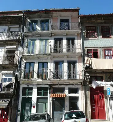 a tall building with cars parked in front of it at Porto Downtown Taipas in Porto