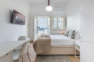 a white bedroom with a bed and a desk at GuestReady - Port Studio 2 in Vila Nova de Gaia