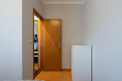 a white refrigerator in a room with a wooden door at Host Wise - Lovely & Cozy House - Prime Location in Vila Nova de Gaia
