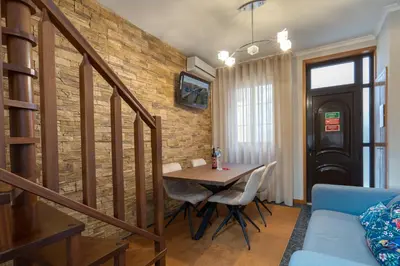 a dining room with a table and a brick wall at Host Wise - Lovely & Cozy House - Prime Location in Vila Nova de Gaia
