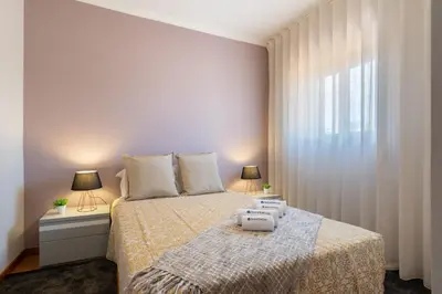 a bedroom with a bed and two lamps and a window at Host Wise - Lovely & Cozy House - Prime Location in Vila Nova de Gaia