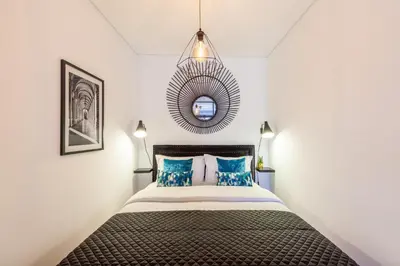 a bedroom with a bed with blue pillows and a mirror at Josephine Apartments in Porto
