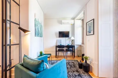 a living room with a blue couch and a table at Josephine Apartments in Porto