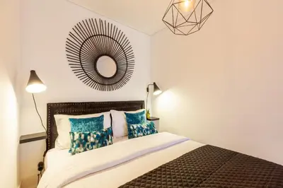 a bedroom with a bed with blue pillows and a mirror at Josephine Apartments in Porto