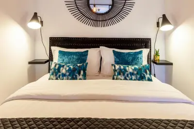a bedroom with a large bed with blue pillows at Josephine Apartments in Porto