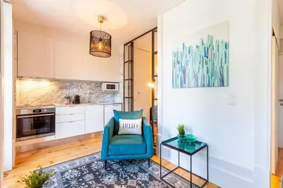 a living room with a blue chair and a table at Josephine Apartments in Porto